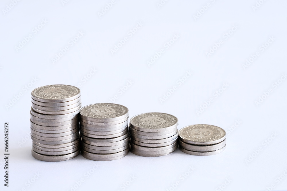 Swiss Franc (CHF) coins showing an decreasing curve to showcase the increasing cost of living and the reducing amount of savings and earnings Swiss Franc (CHF) coins showing an decreasing curve to showcase the increasing cost of living and the reducing amount of savings and earnings