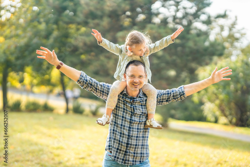 Father and little daughter having fun together in autumn park at sunset light in Prague, Europe