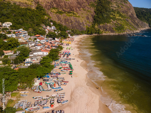 Foto de drone de Barcos e guarda-sóis na beira da praia
