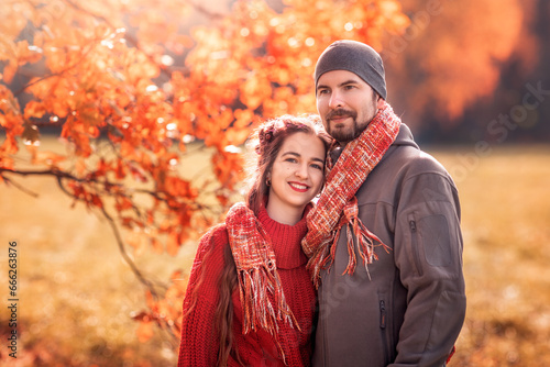 young couple in love in an autumn park on a bright sunny day. Portrait of couple enjoying golden autumn fall season
