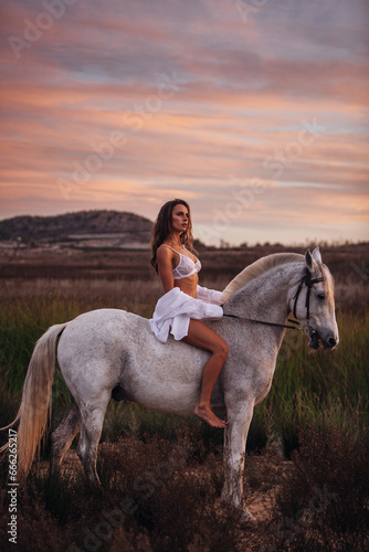 Portrait of a white horse and sexy woman. Beautiful glamour woman with a horse. Portrait of a beauty undressed woman with horse.