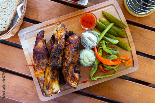 Czech popular dish Pecena veprova zebra, grilled pork ribs served with horseradish, mustard, marinated peppers and cucumbers photo