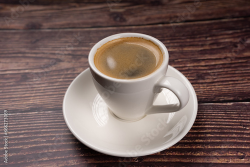 Close up of espresso coffee in white cup, on wooden table, vintage color tone, 