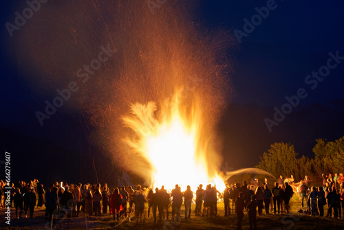Big bonfire with sparks and people around. Salzkammergut region, Austria.