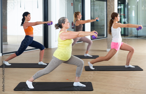 Positive women practicing pilates with balls at group class in yoga studio