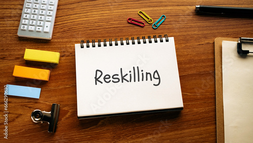 There is notebook with the word Reskilling. It is as an eye-catching image.