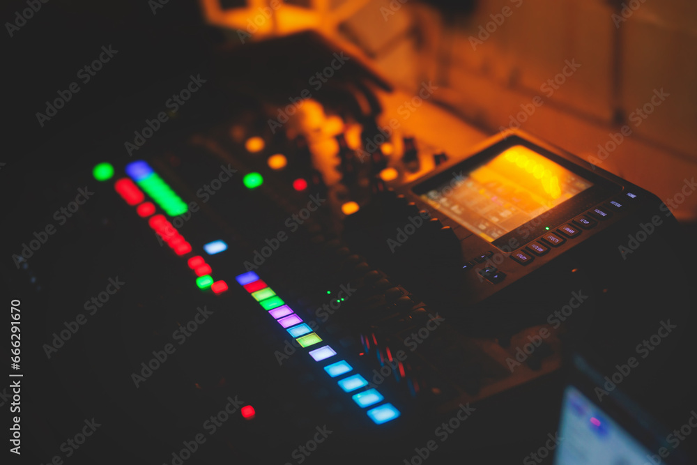 View of lighting technician operator working on mixing console ...