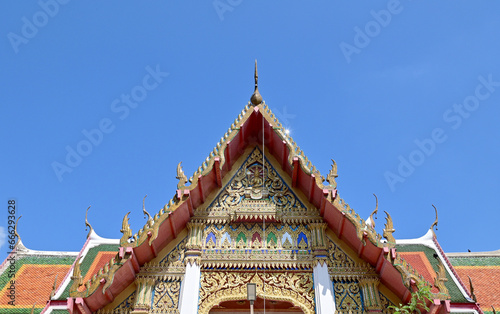 BANGKOK, THAILAND - October 22, 2023 : Part of the Roof of a temple in Thailand. Traditional Thai style pattern on the roof of a temple with Blue Sky Background. © masterjew