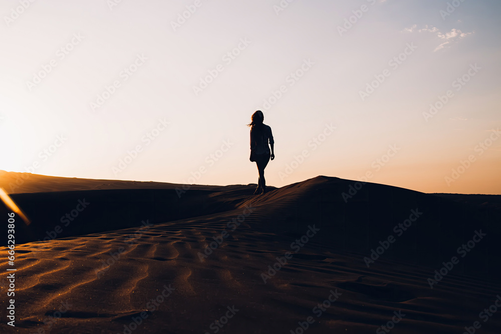 Sunset desert landscape with silhouette of woman