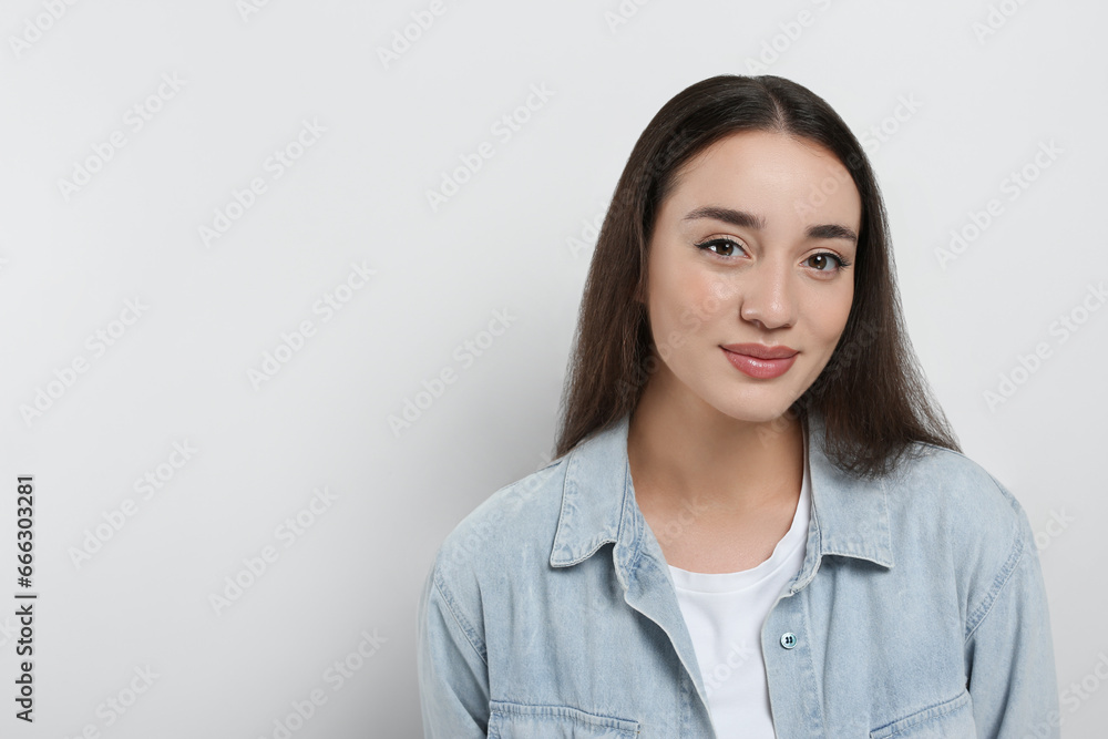 Portrait of beautiful young woman in jeans jacket on white background. Space for text Portrait of beautiful young woman in jeans jacket on white background. Space for text