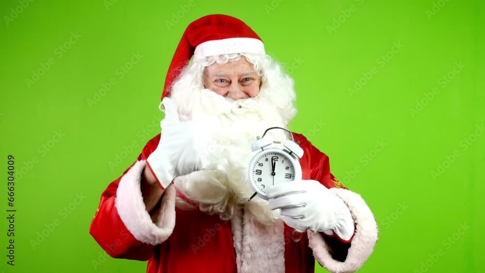 Authentic joyful Santa Claus holding alarm clock and pointing on clock face. Authentic joyful Santa Claus holding alarm clock and pointing on clock face.