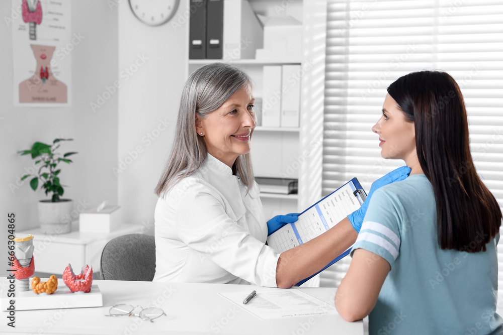 Endocrinologist examining thyroid gland of patient at table in hospital Endocrinologist examining thyroid gland of patient at table in hospital