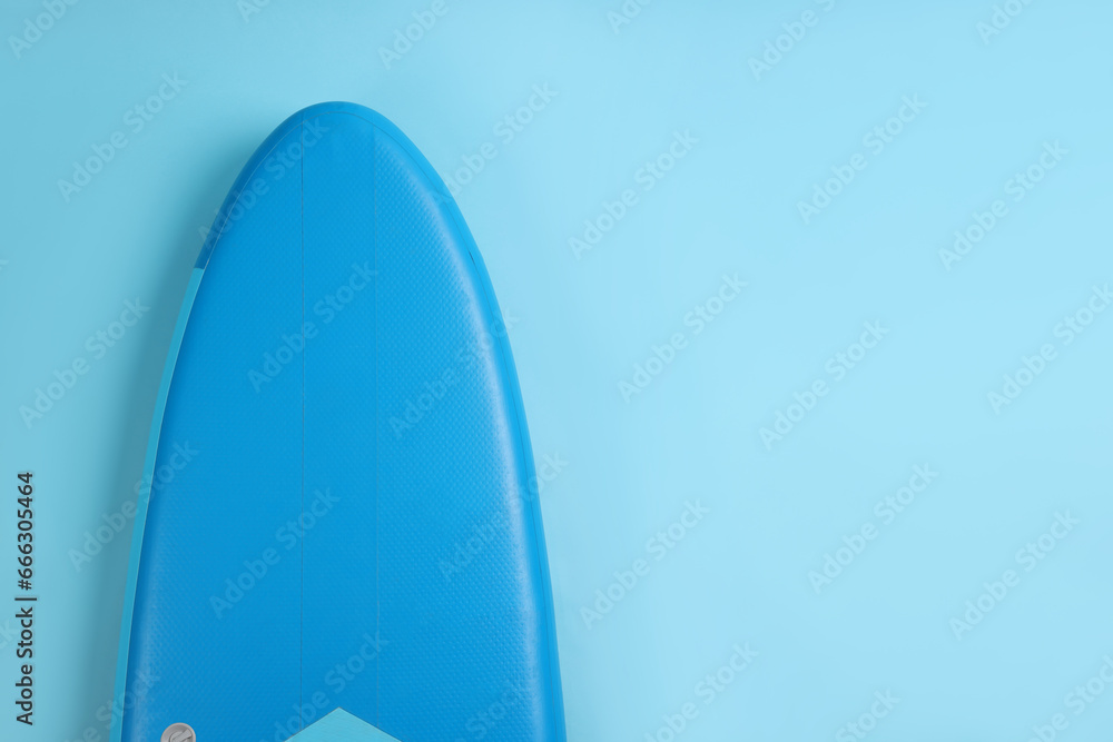 One SUP board on light blue background, top view with space for text. Water sport One SUP board on light blue background, top view with space for text. Water sport