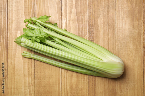 Bunch of fresh green celery on wooden table, top view