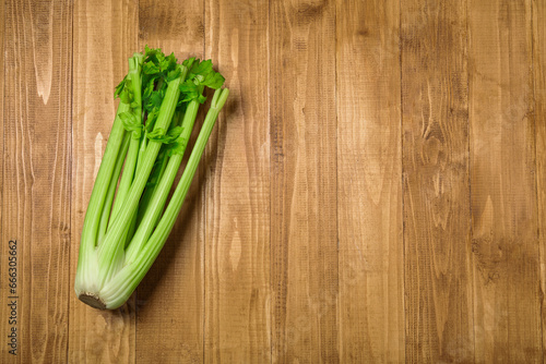 Bunch of fresh green celery on wooden table, top view. Space for text