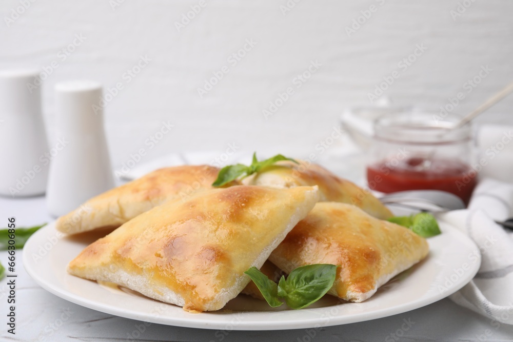Delicious samosas and basil on white table, closeup Delicious samosas and basil on white table, closeup