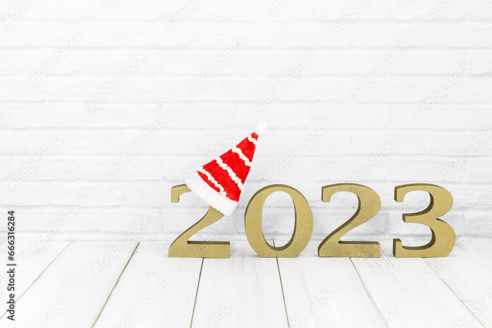 Obraz premium 2023 new year and christmas hat on white wood table over white background with copy space