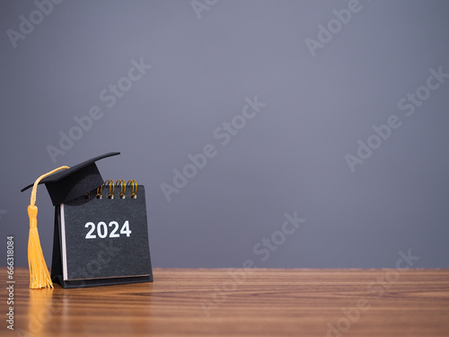 Study goals, 2024 Desk calendar with graduation hat. The concept for Resolution, Goal, Action, Planning, and manage time to success graduate.