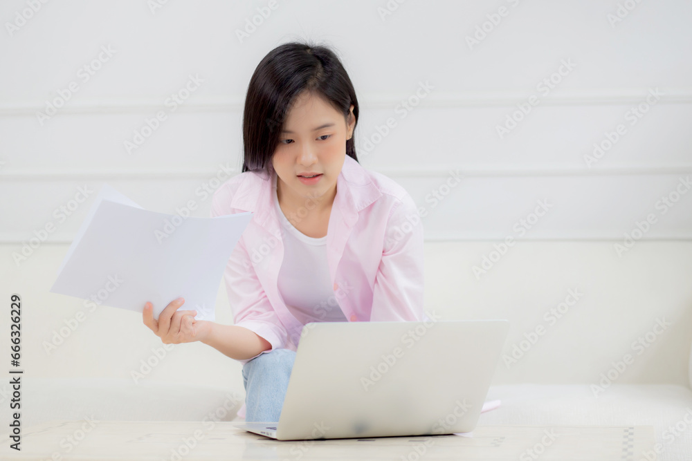 Young asian business woman working on laptop computer and looking graph and chart of report for profit on paper at home, businesswoman looking investment and income, data of infographic statistics. Young asian business woman working on laptop computer and looking graph and chart of report for profit on paper at home, businesswoman looking investment and income, data of infographic statistics.