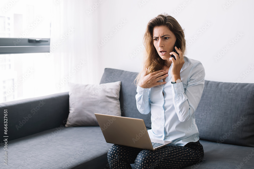 Amazed woman calling on phone sitting with computer Amazed woman calling on phone sitting with computer
