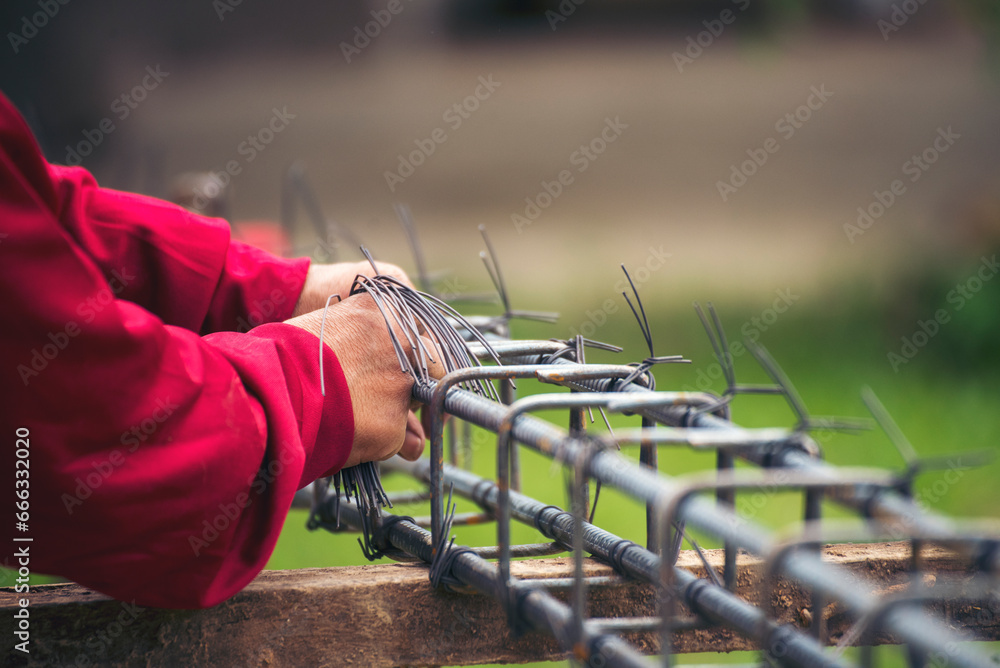 Men hands using pincer pliers iron wire reinforcement of concrete work. Construction Worker hands bending cutting steel wire fences bar. Outdoor Worker using wire bending pliers, construction work. - obrazy, fototapety, plakaty 