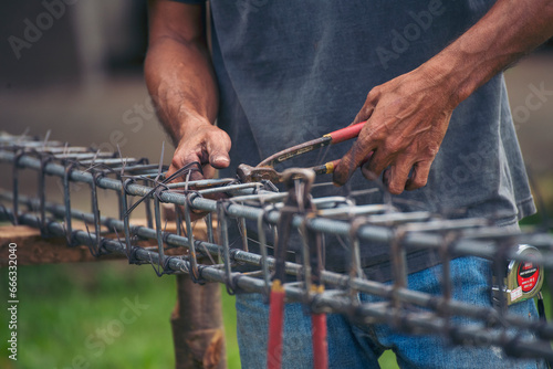Construction Men hands bending cutting steel wire fences bar reinforcement of concrete work. Worker hands using pincer pliers iron wire. Outdoor Worker using wire bending pliers, construction work