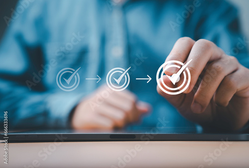 Billede på lærred Businessman using electronic pen of tablet to tick correct sign mark for document approve of quality assurance and project accept concept