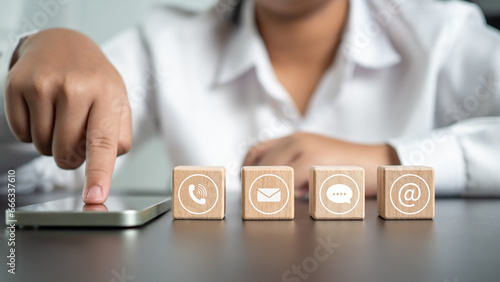 Businesswoman pointing finger at phone screen with communication icons for support or providing services and consulting to customers.