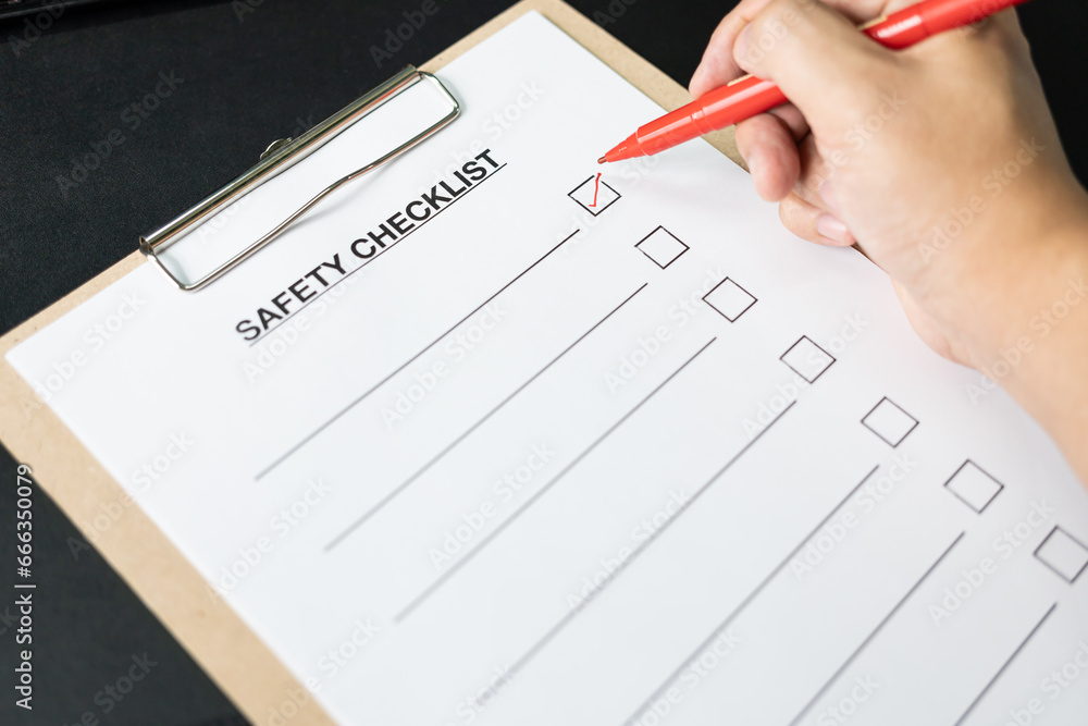Blank checklist paper during safety audit and risk verification. safety checklist form on the desk with red pen. Blank checklist paper during safety audit and risk verification. safety checklist form on the desk with red pen.