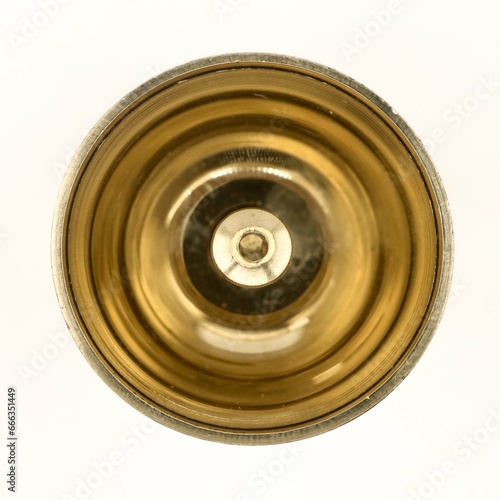 a shiny round brass oil lamp with wick holder isolated in a white background viewed from the top