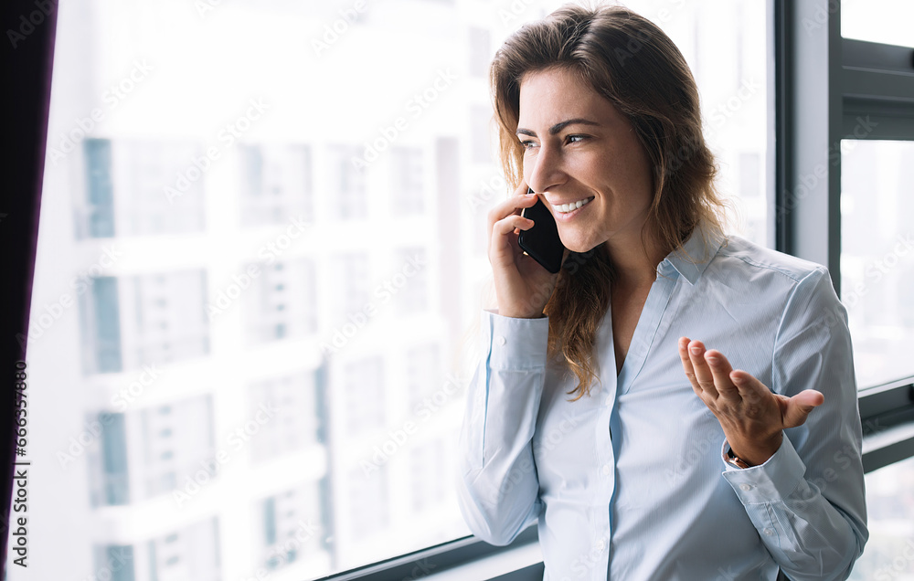 Young adult lady talking on phone near window Young adult lady talking on phone near window