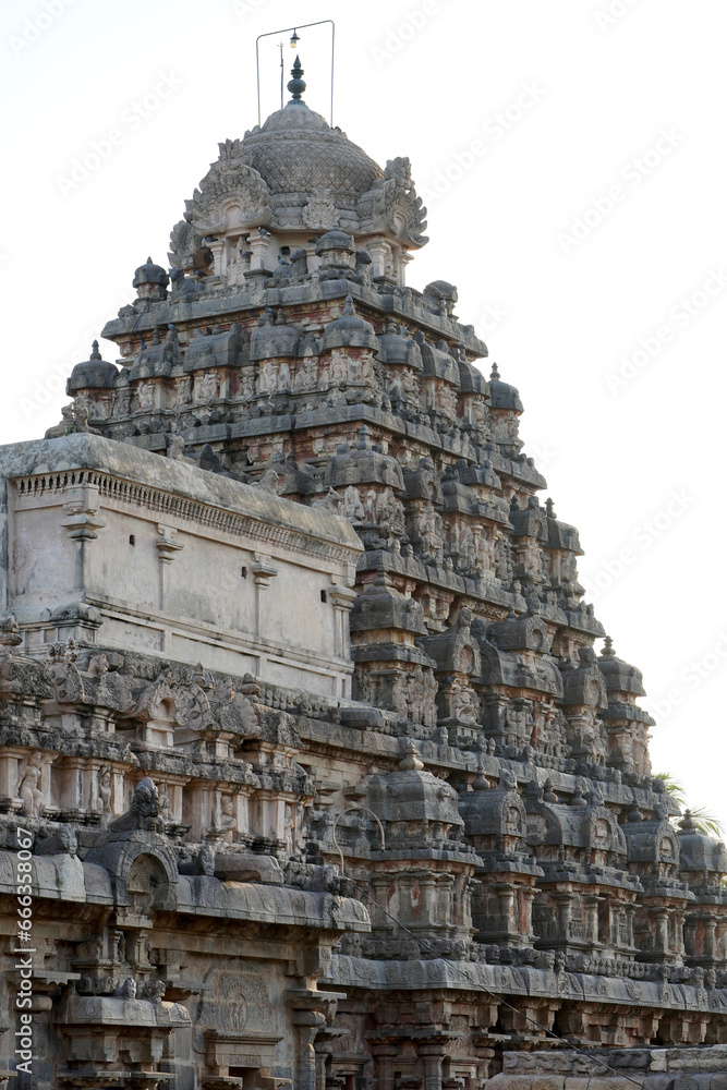 Tower of Airavatesvara Temple, Darasuram, Kumbakonam, Tamilnadu. Ancient hindu temple tower with carvings of God sculpture isolated against blue sky background in Tamilnadu.
