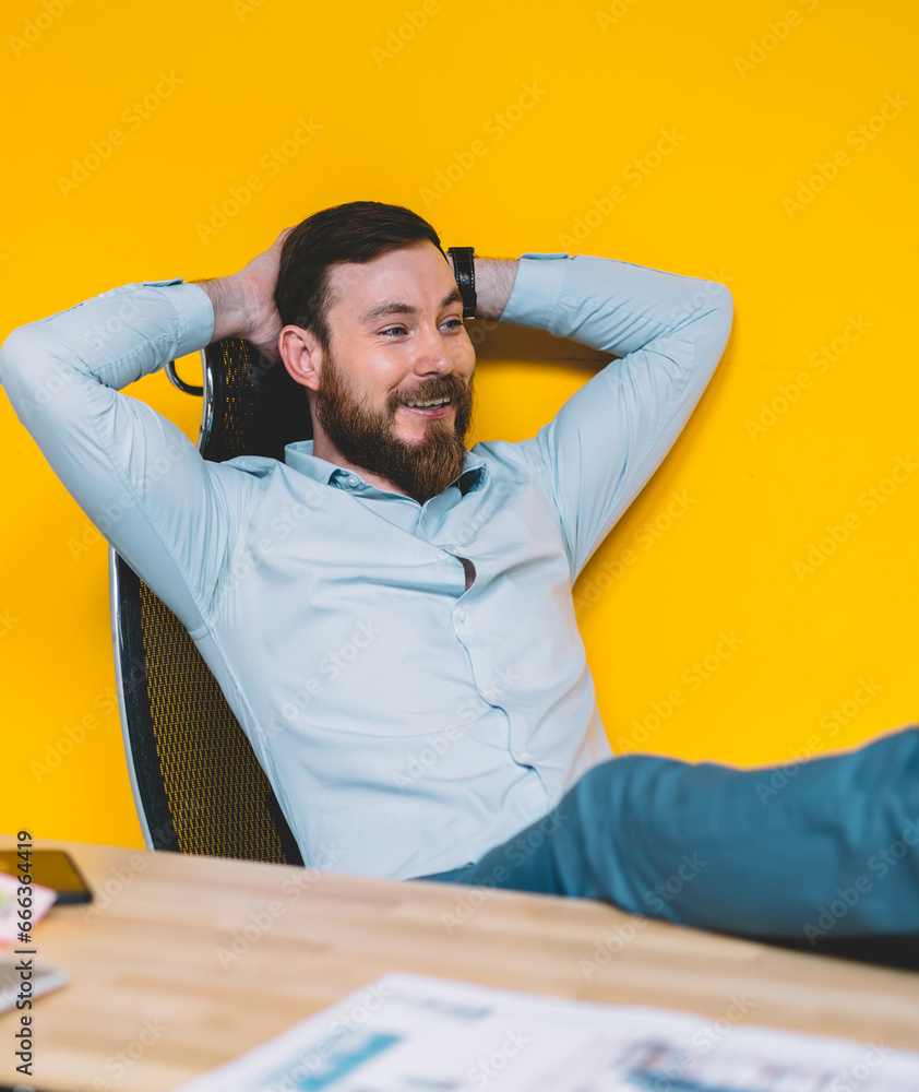 positive smiling businessman in formal wear taking back and relaxing in office interior positive smiling businessman in formal wear taking back and relaxing in office interior