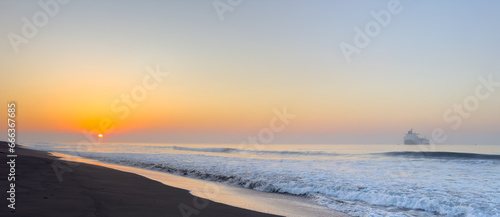 Beautiful sunrise over the black sand beach of Port of San Jose in Guatemala photo