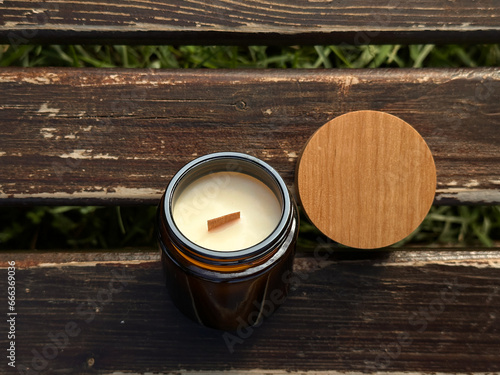 The natural soy candle with a wooden wick in a brown glass jar