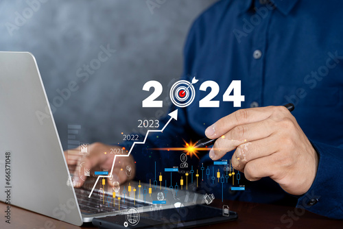 Businessman working on digital laptop computer with digital graph chart graphic, positive indicators in 2024, business calculate financial data, Digital marketing, finance.