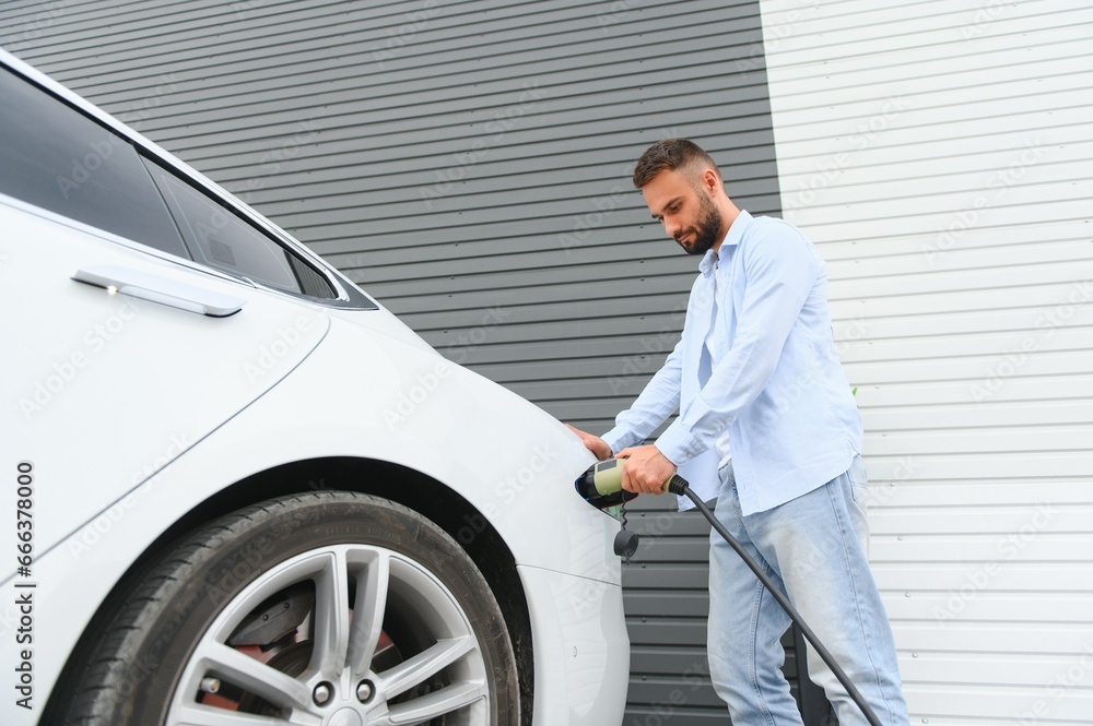 Man standing by his electric car Man standing by his electric car