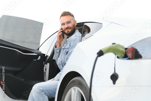 a man charges an electric car © Serhii
