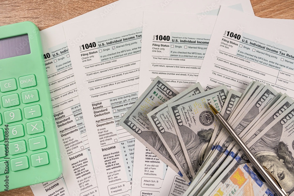 Obraz premium Individual Income Tax Return 1040 wirh dollar cash pen and calculator on office desk