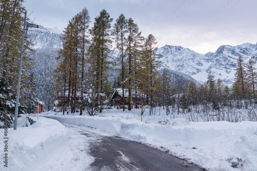 Traditional village in winter with snow. Macugnaga, northern Italy. Important ski resort in the European Alps with Monte Rosa. Street leading to old church