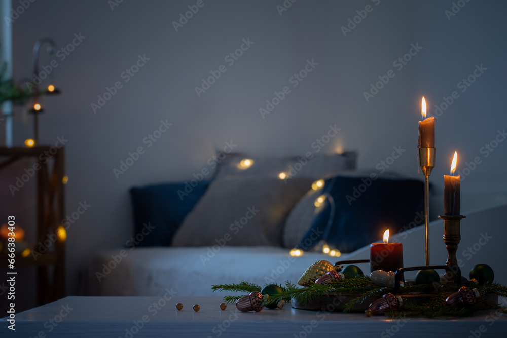 burning candles with christmas decor in white cozy interior - obrazy, fototapety, plakaty 