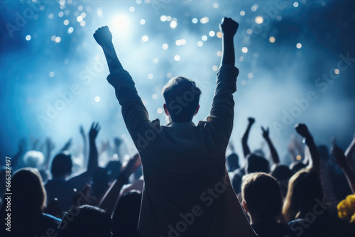 Man enthusiastically raises his arms in air, caught in moment of lively concert. Excitement and energy of live music events. Vibrant atmosphere of concerts and joy of being part of crowd.