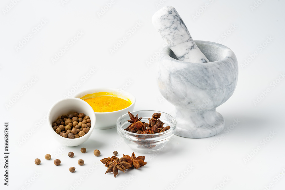 Marble mortar and pestle with spices on white background Marble mortar and pestle with spices on white background