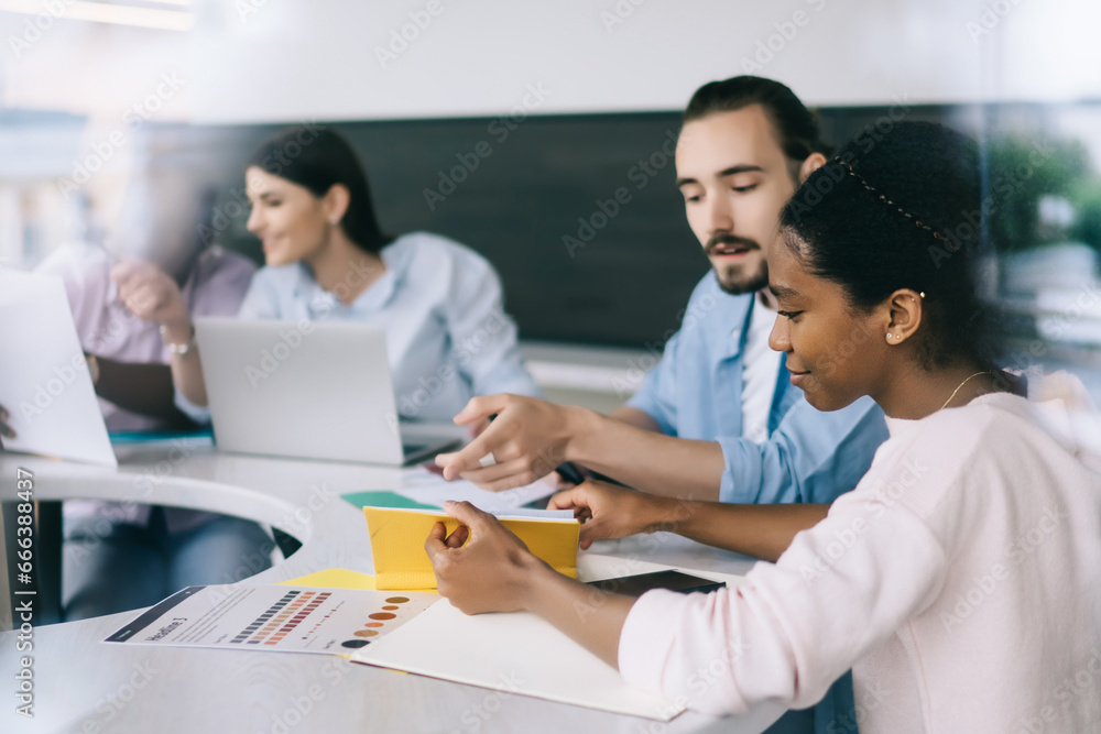 Multiethnic coworkers sitting at table n office Multiethnic coworkers sitting at table n office