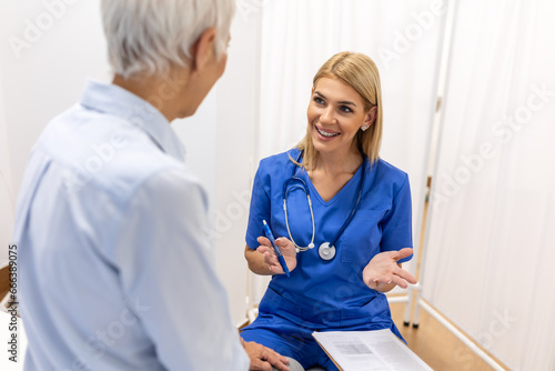 Lets set up an appointment for next week. Young female doctor going through medical records with his senior female patient. photo