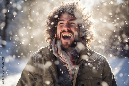 A man in winter clothes plays in the snow in front of house © toonsteb