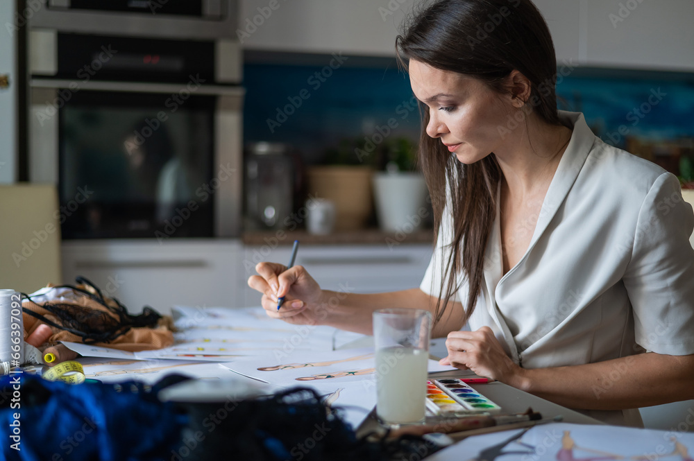 Fototapeta premium Woman drawing sketches of swimwear and underwear in watercolor.