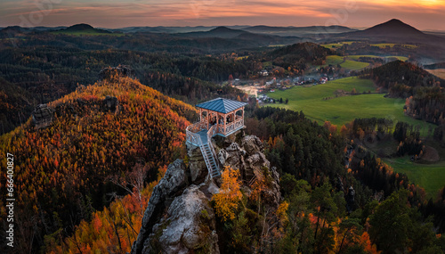 Jetrichovice, Czech Republic - Aerial panoramic view of Mariina Vyhlidka (Mary's view) lookout at sunset with foggy Czech autumn landscape and colorful sky in Bohemian Switzerland region
