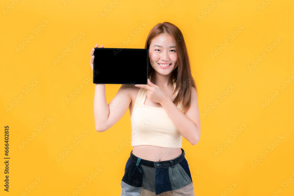 beautiful Asian young woman showing smart phone , tablet phone computer with blank screen ,black screen ,empty copy space for advertising banner isolated on on yellow background , Mock Up Image beautiful Asian young woman showing smart phone , tablet phone computer with blank screen ,black screen ,empty copy space for advertising banner isolated on on yellow background , Mock Up Image