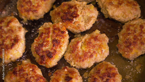 Process of cooking meat cutlets in oil in frying pan.